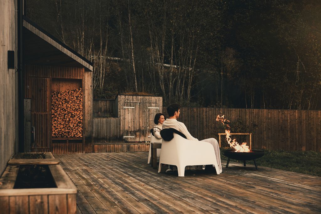Guests in blankets by the fire bowl in the sheltered courtyard