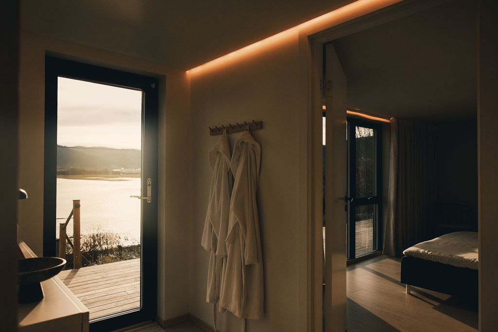 White robes hanging by the door out to the deck and the fjord