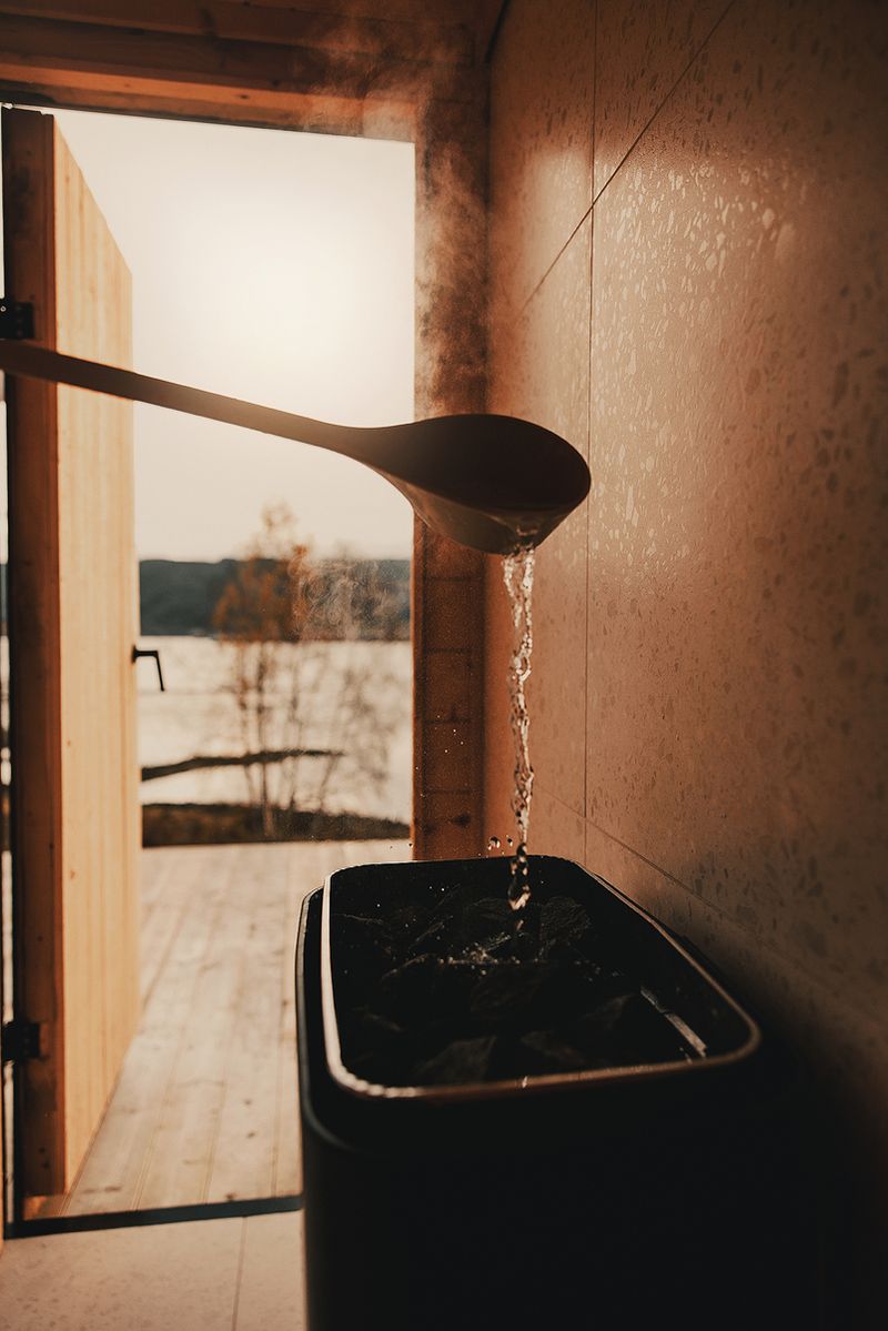 Water poured from a wooden ladle onto the hot sauna stones